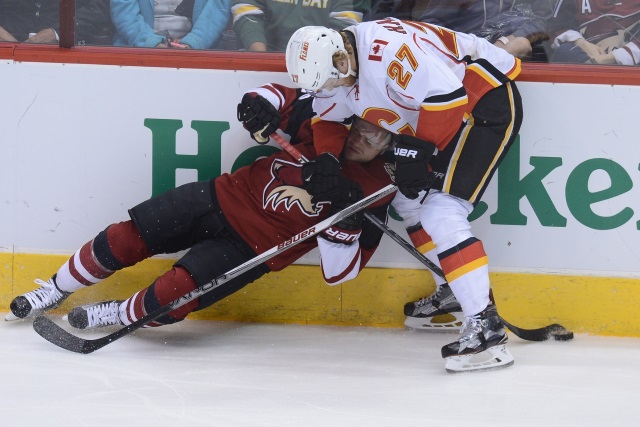 Calgary Flames Dougie Hamilton taking down Arizona Coyotes forward Max Domi