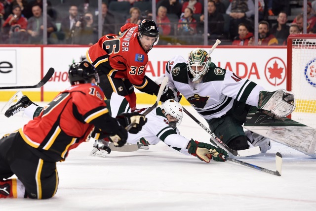 Matthew Tkachuk of the Calgary Flames and Devan Dubnyk of the Minnesota Wild