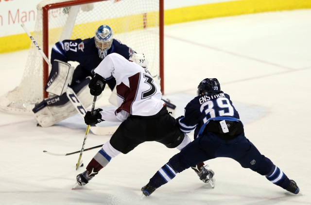 Toby Enstrom of the Winnipeg Jets and J.T. Compher of the Colorado Avalanche