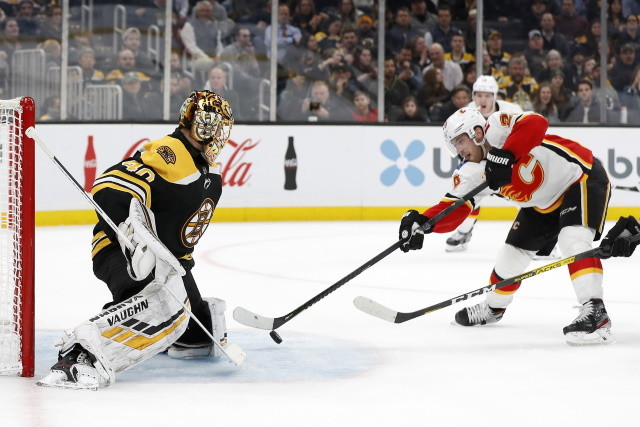 Tuukka Rask of the Boston Bruins and Elias Lindholm of the Calgary Flames